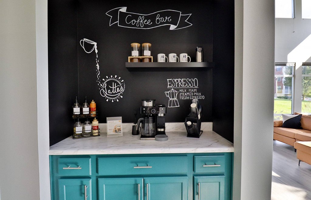 a coffee bar with turquoise cabinets and a black wall