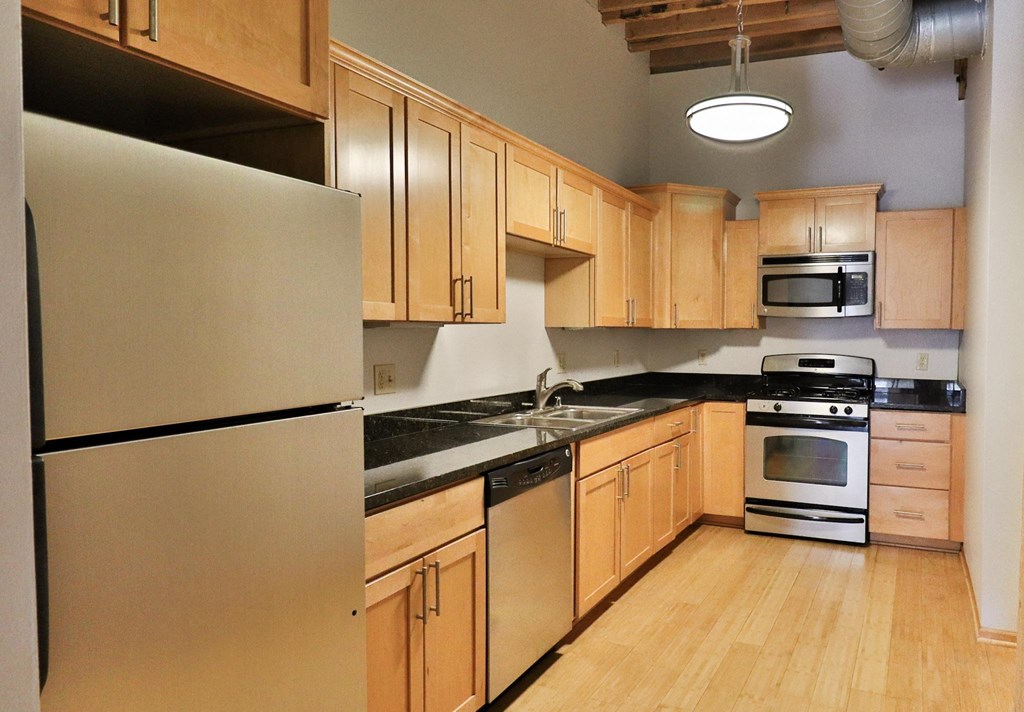 a kitchen with wooden cabinets and stainless steel appliances