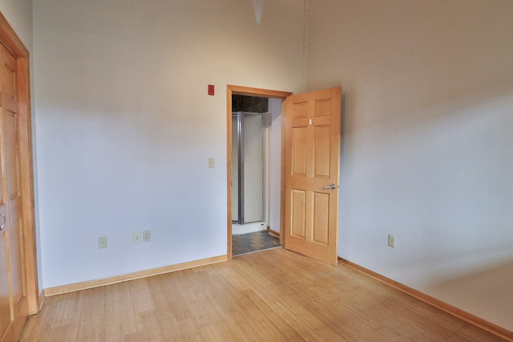 an empty room with a wooden floor and an open door