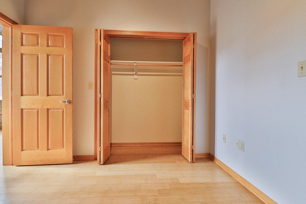an empty room with a closet and a door open