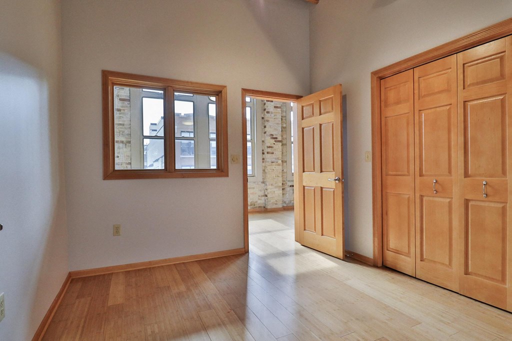 an empty living room with wooden doors and windows