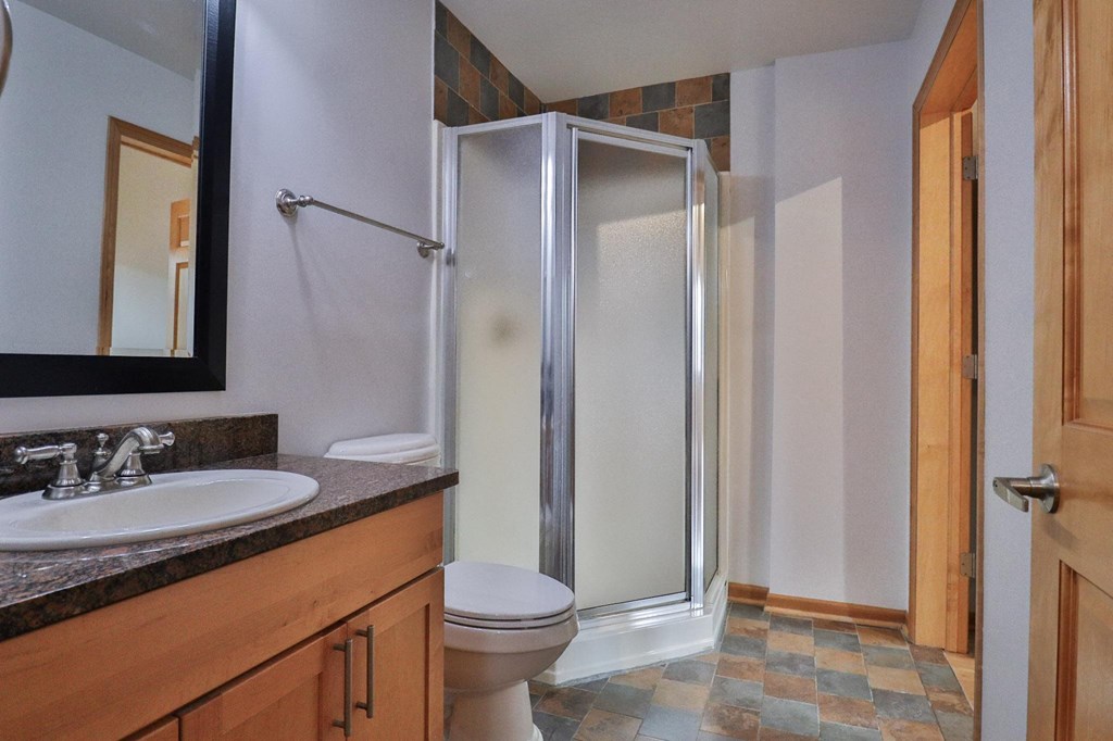 a bathroom with a shower and a sink and a toilet