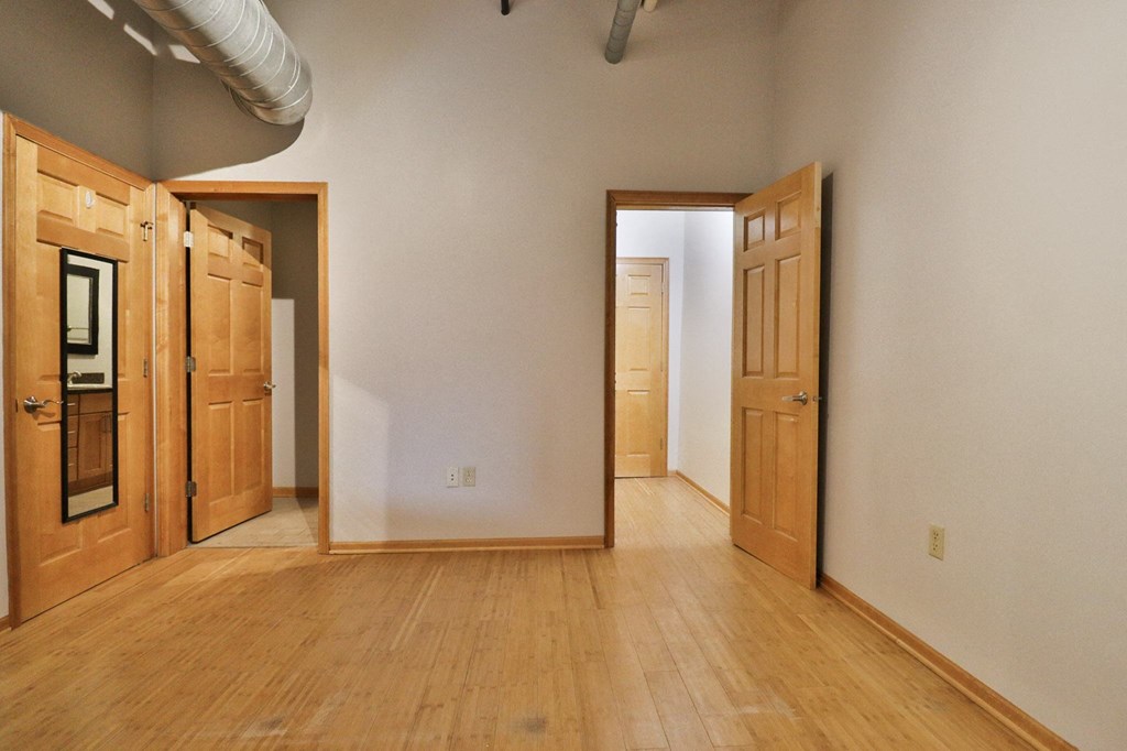 an empty living room with wooden floors and wooden doors