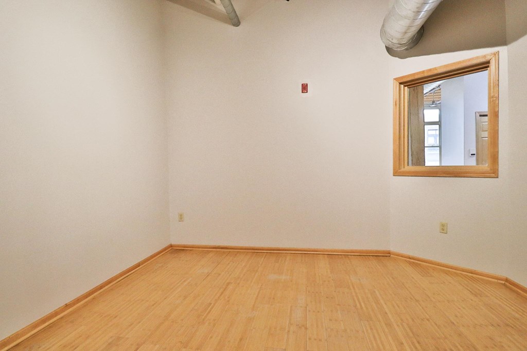 an empty room with a wooden floor and a window