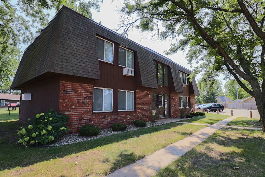 a red brick house with a sidewalk in front of it
