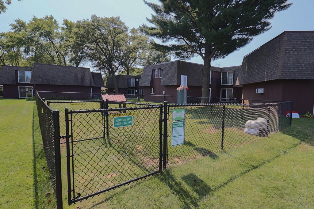 a view of a fenced in yard in front of an apartment building