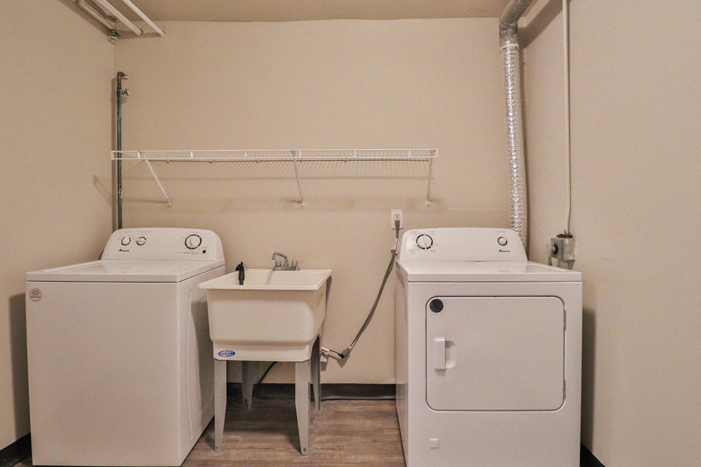 two washers and a sink in a room with a dryer
