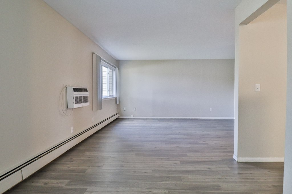 an empty living room with white walls and a window