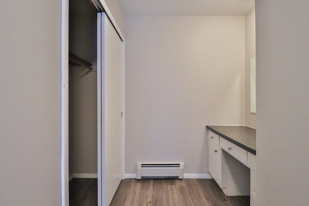 an empty room with a kitchen and a closet
