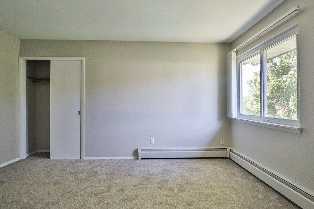 an empty room with white walls and a window