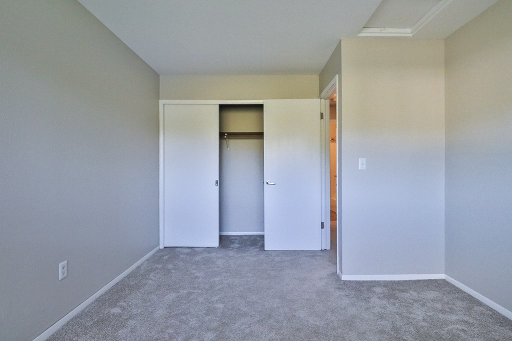 an empty room with white walls and a closet