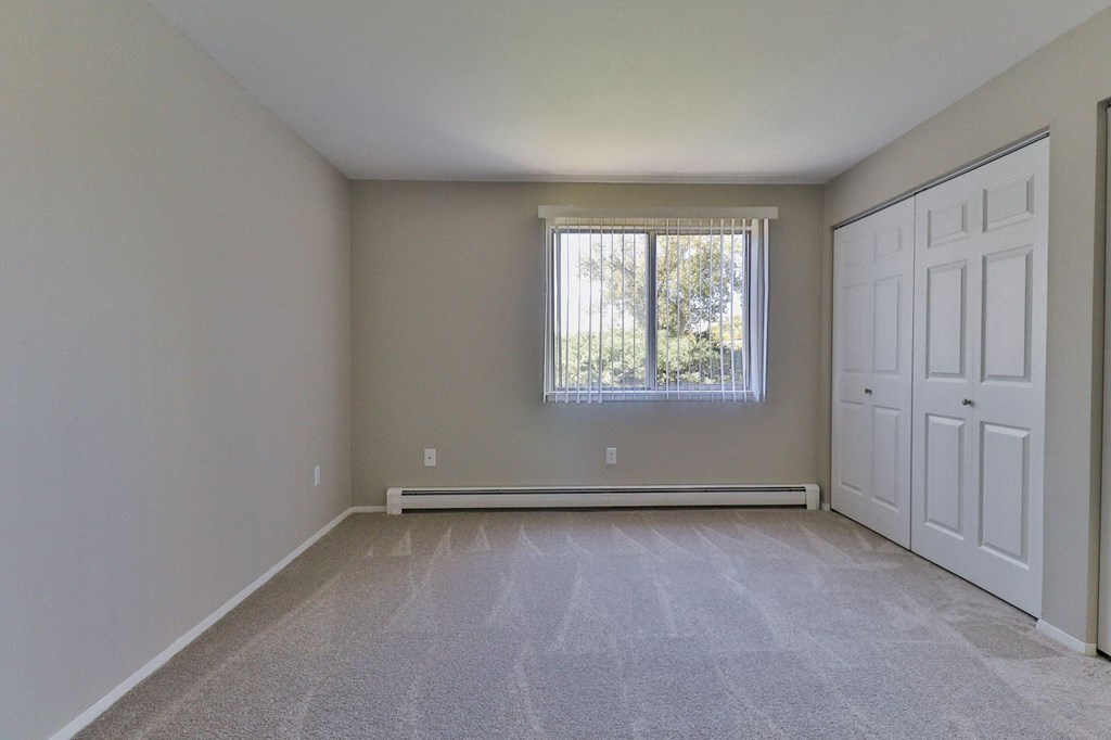 an empty room with two doors and a window