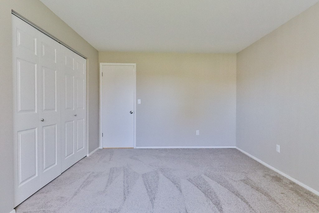 an empty bedroom with white walls and white doors