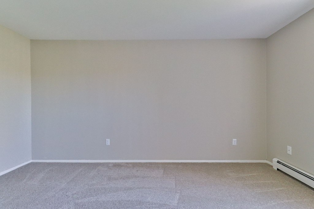 an empty room with beige walls and a tiled floor