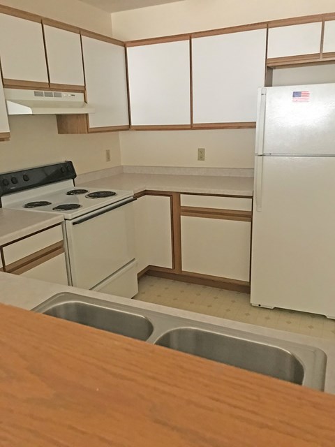 A kitchen with a white fridge and a stove top oven.