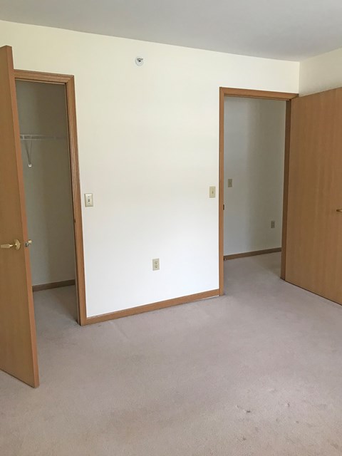 A room with two doors and a carpeted floor.