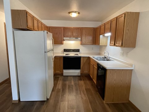 A kitchen with wooden cabinets and a white refrigerator.
