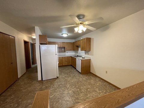 A kitchen with a refrigerator, microwave, and sink.