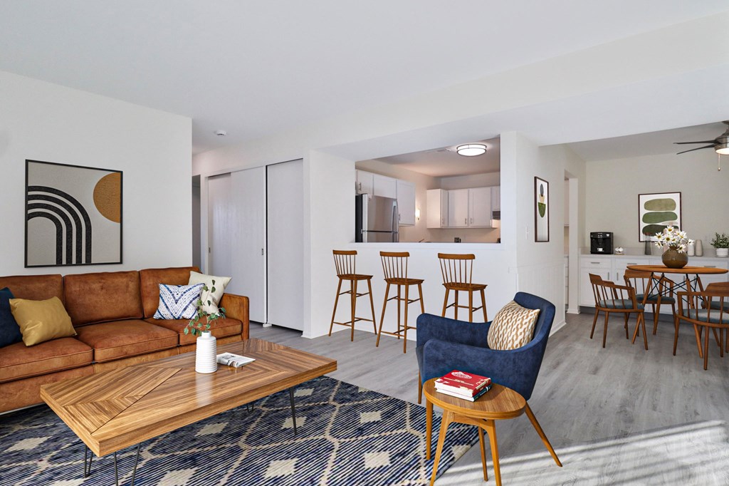 A living room with a brown couch, a coffee table, and a blue chair.
