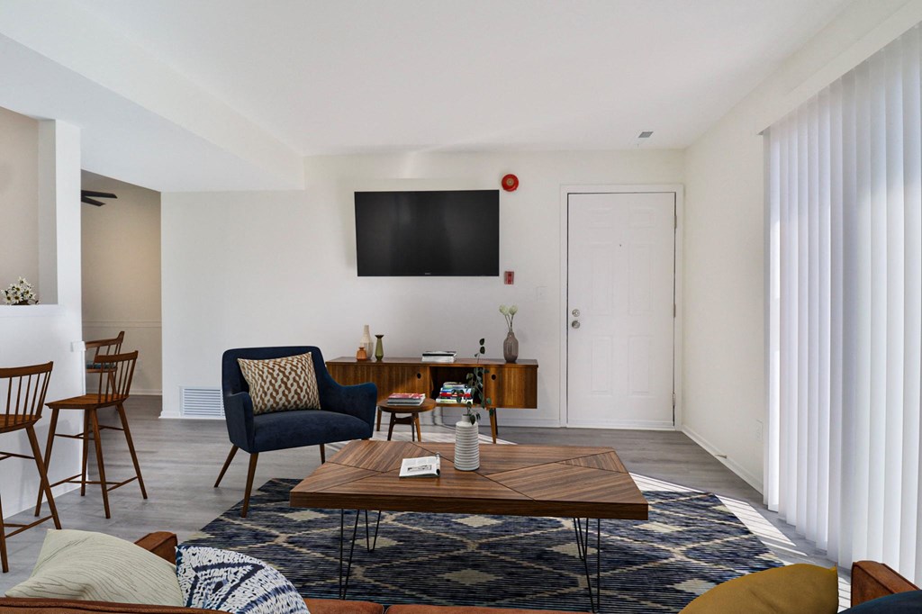 A living room with a blue chair and a wooden coffee table.