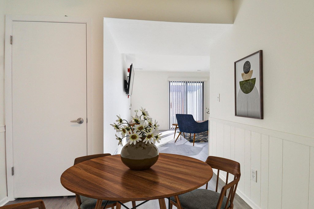 A dining room with a wooden table and chairs.