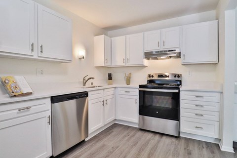 A kitchen with white cabinets and stainless steel appliances.