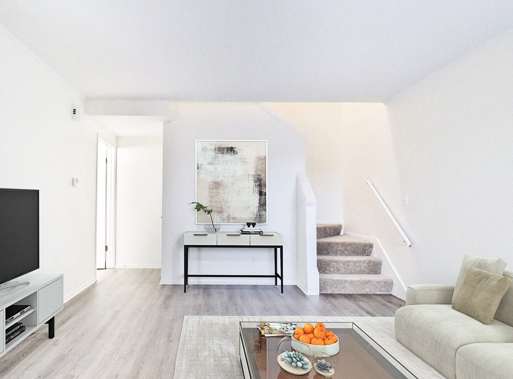 A living room with a couch, a coffee table, and a painting on the wall.