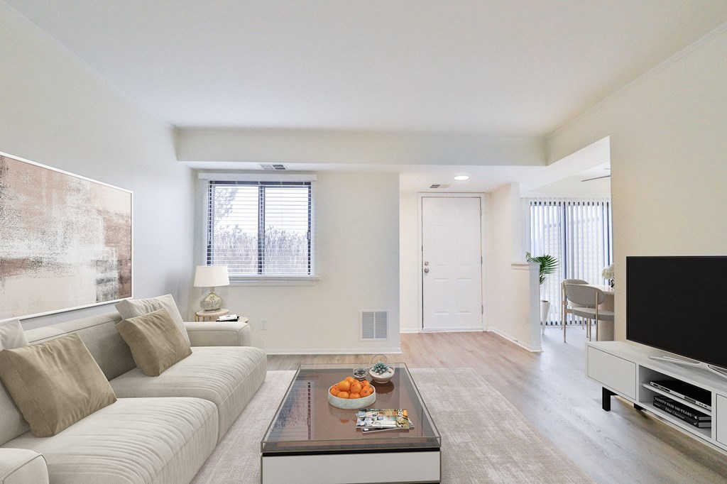 A living room with a white couch and a coffee table in front of it.