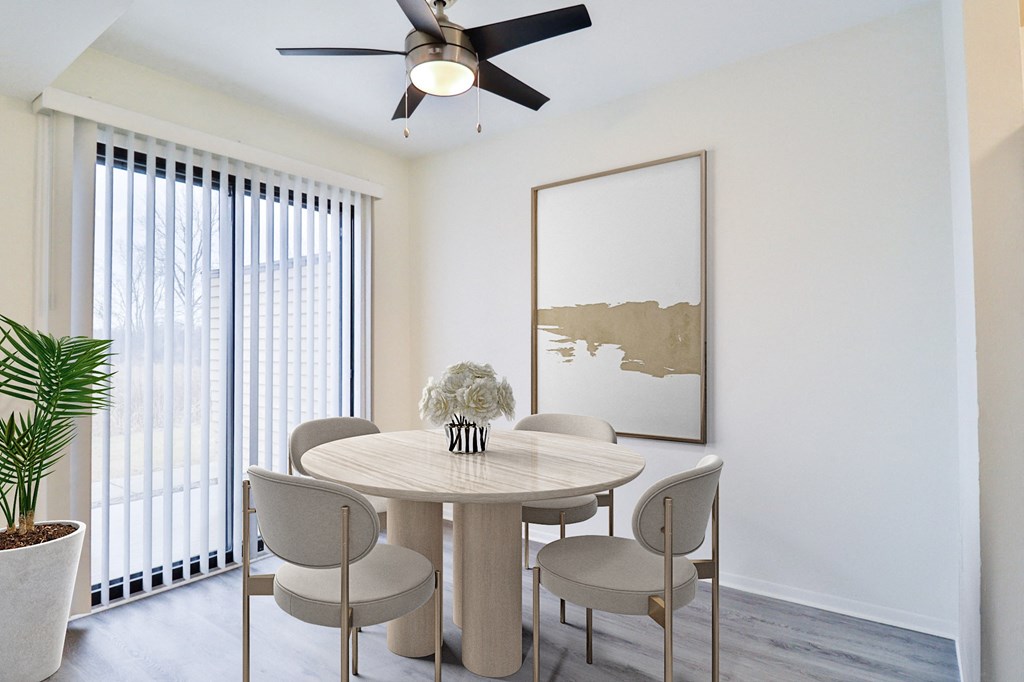 A dining room with a round table and chairs.