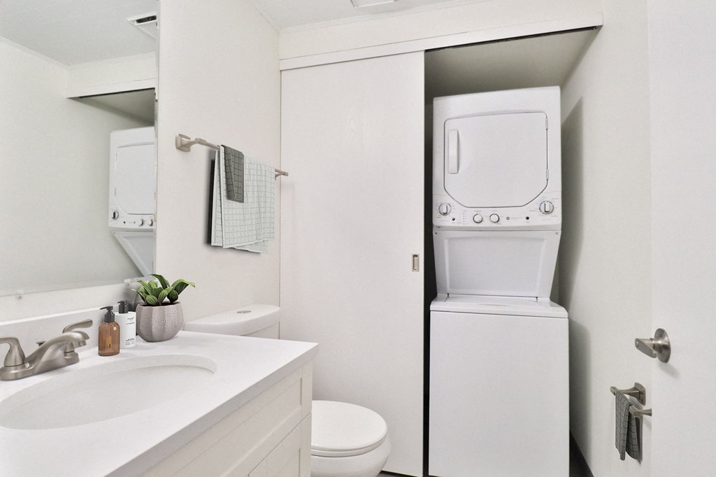 A white toilet is in a bathroom next to a sink.