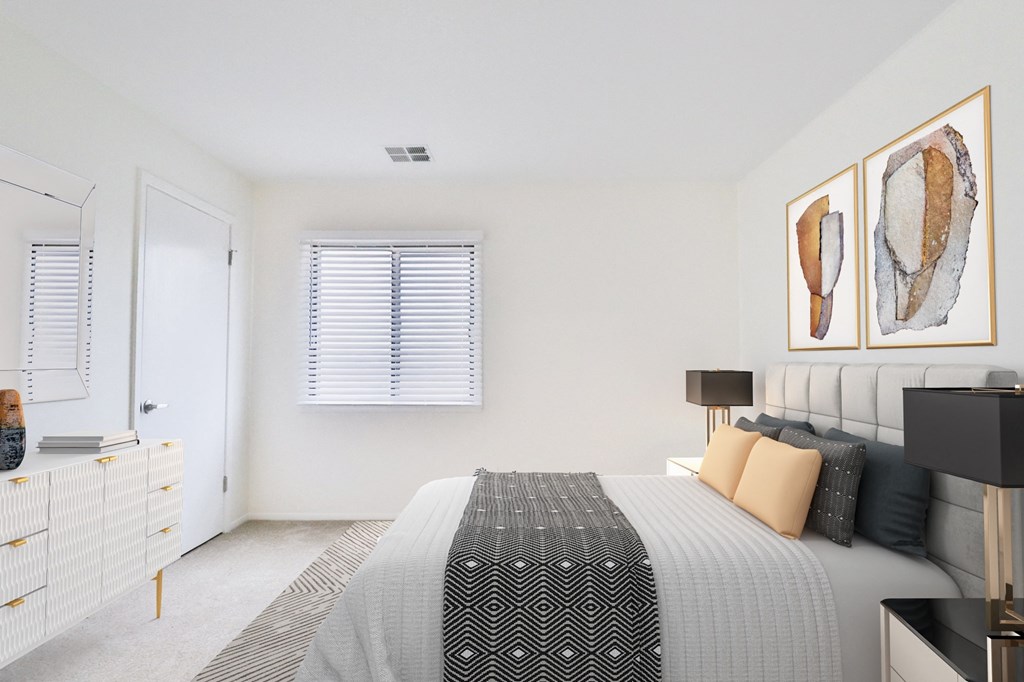 A bedroom with a bed, nightstand, and two framed pictures on the wall.
