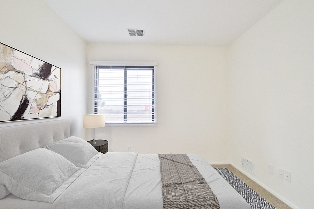 A bedroom with a large bed and a painting on the wall.