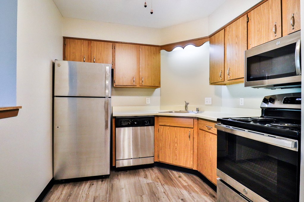A kitchen with wooden cabinets and stainless steel appliances.