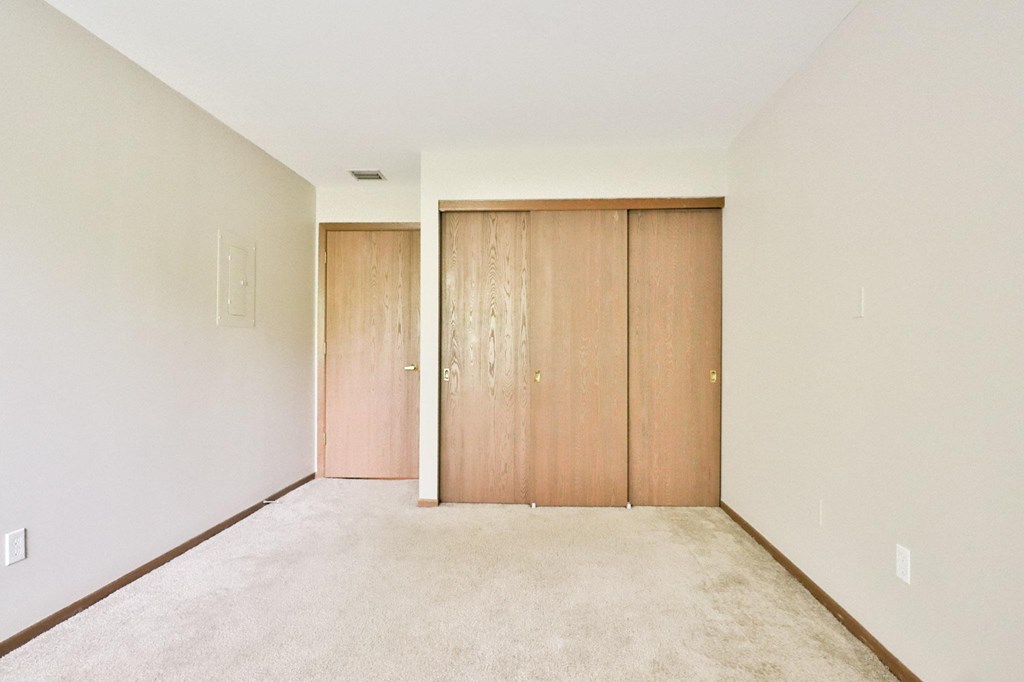 A room with two doors and carpeted floor.