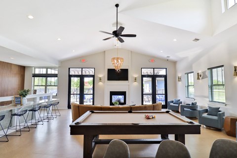 A billiard table is in the middle of a room with a pool table light.