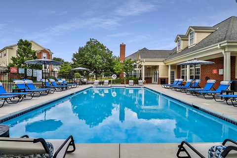 A large swimming pool with lounge chairs and umbrellas.