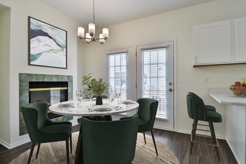 A dining room with a white table and green chairs.