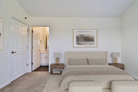 A bedroom with a large bed and a painting on the wall.