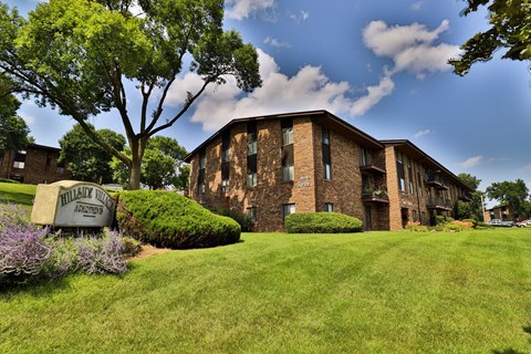 A building with a sign that says "Willisville Apartments" in front of it.