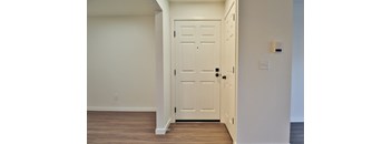 A white door is in a white room.