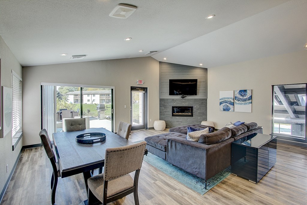 a living and dining room area with a couch table and chairs and a fireplace