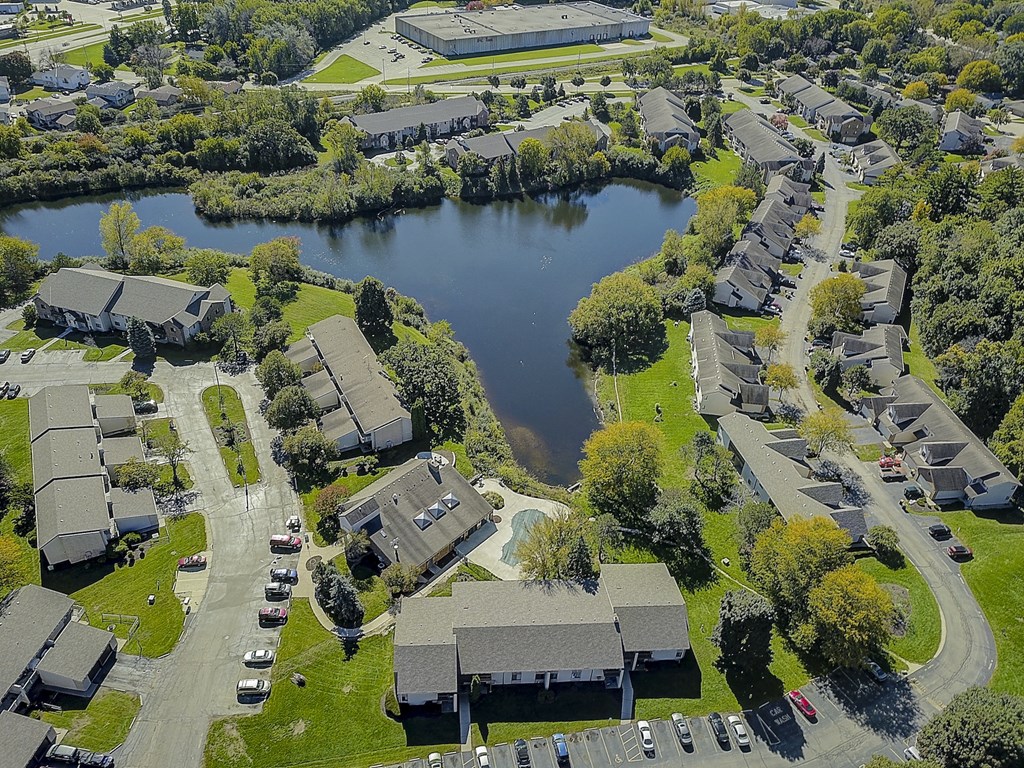 an aerial view of a neighborhood with a lake in the background