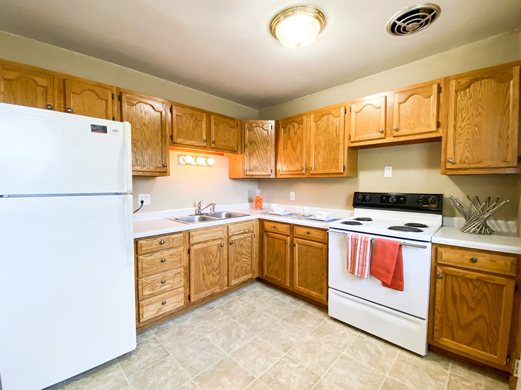 a kitchen with white appliances and wooden cabinets