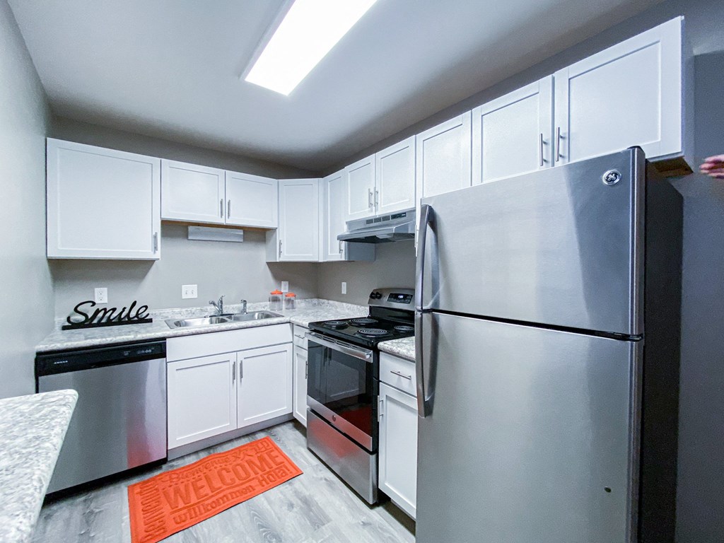 a kitchen with stainless steel appliances and white cabinets