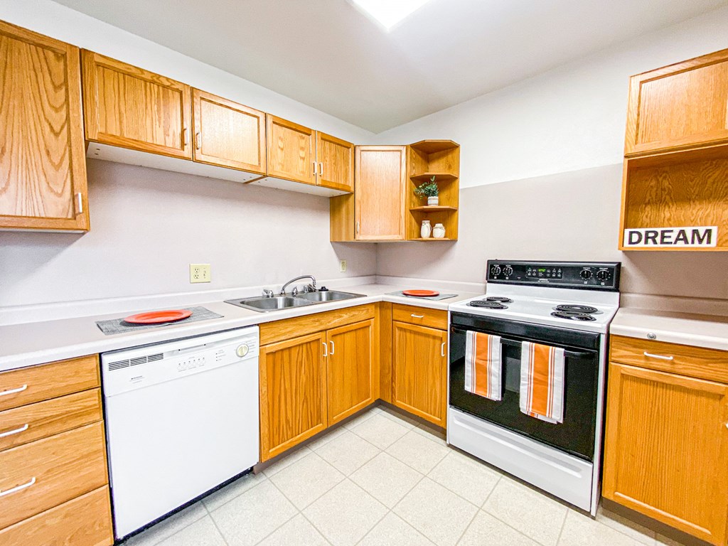 a kitchen with white appliances and wooden cabinets