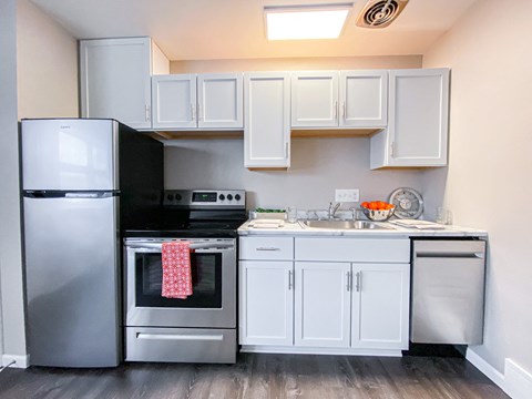 a small kitchen with stainless steel appliances and white cabinets
