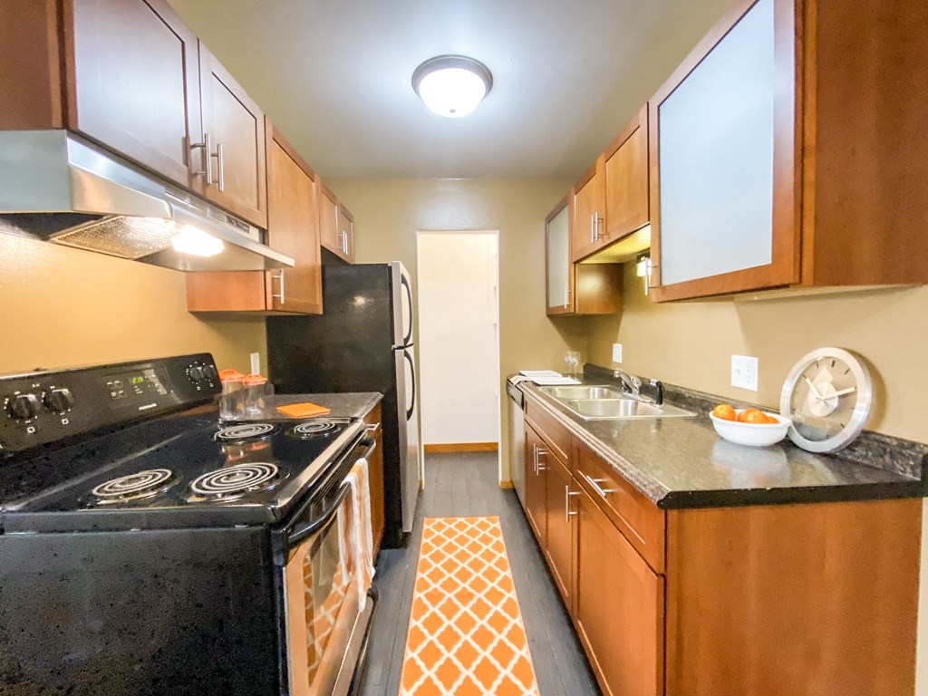a kitchen with a stove and a sink and a refrigerator