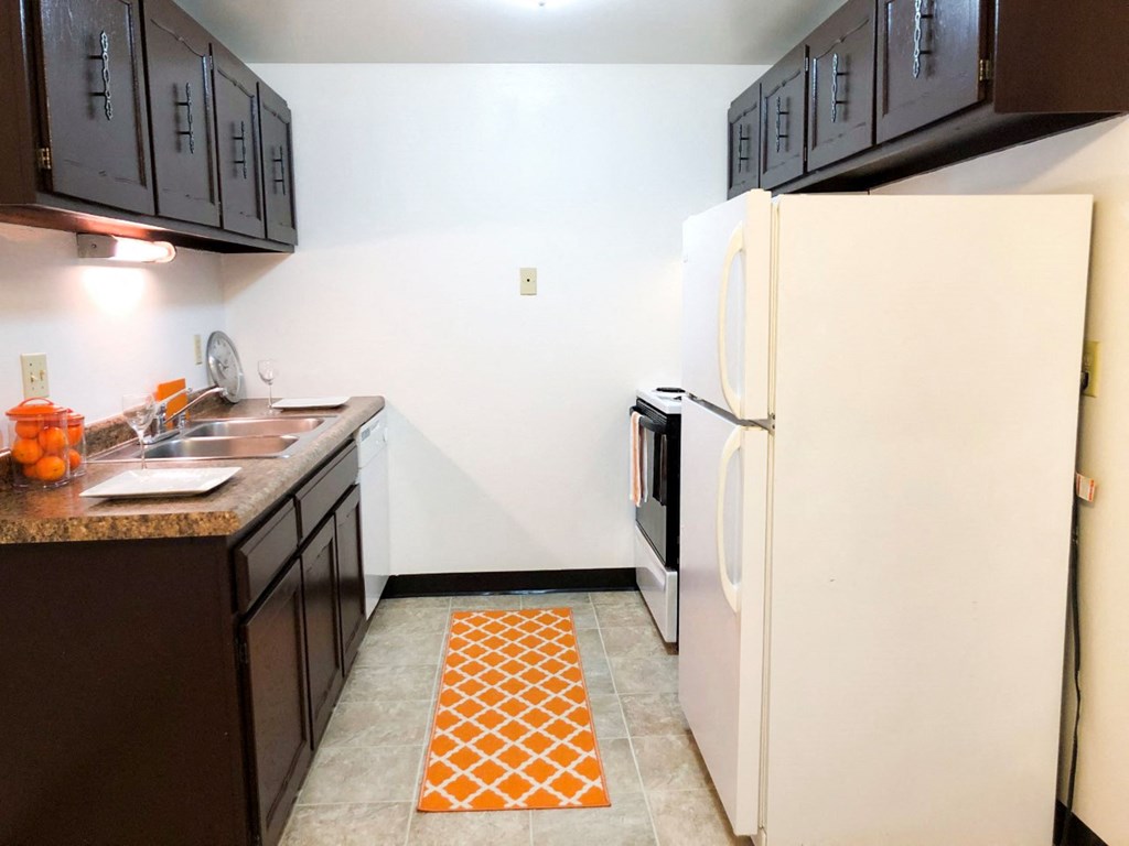a kitchen with black cabinets and a white refrigerator