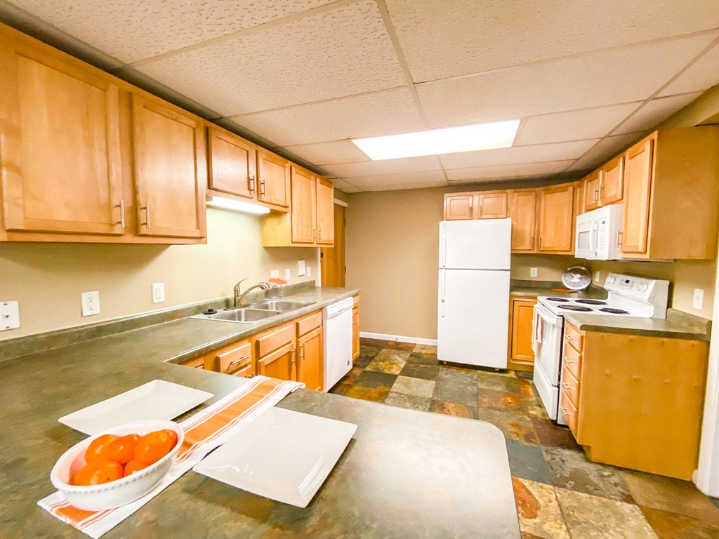 a kitchen with a bowl of oranges on the counter