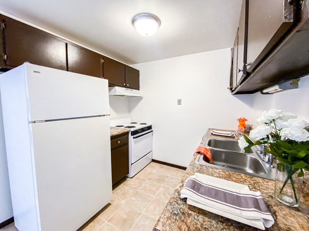 a kitchen with white appliances and a sink and a refrigerator